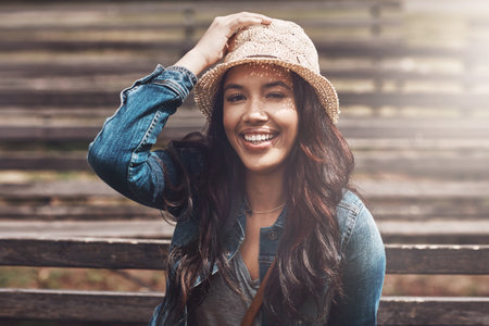 Summertime smiles all around. Portrait of an attractive young woman spending a day in the park.の写真素材