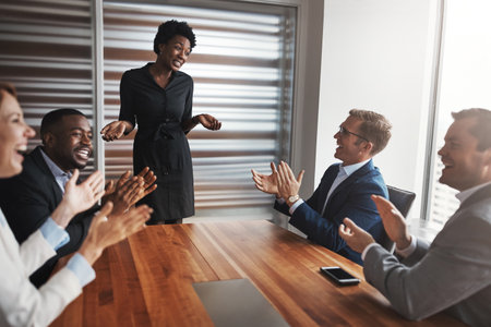 Concluding her talk on a high note. a group of businesspeople applauding a colleague in an office.の写真素材