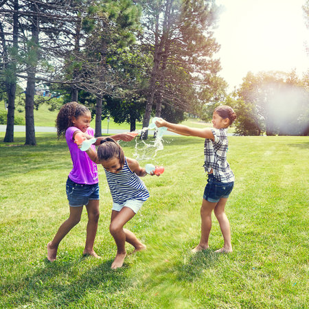 Having fun with water. adorable little girls playing with water balloons outdoors.