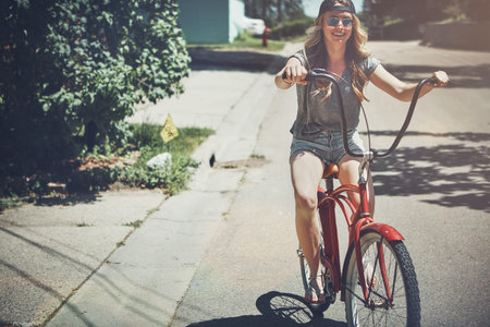 No need to walk when youve got cool wheels. an attractive young woman riding a bicycle outdoors.