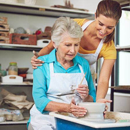 Happiness is handmade. a senior woman making a ceramic pot at a pottery class.の写真素材