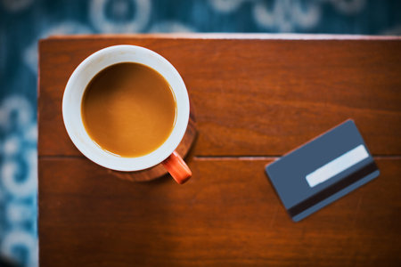 Pay for coffee at your convenience. High angle shot of a cup of coffee and credit card on a table.