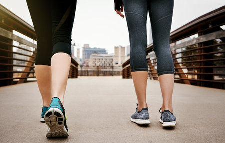 Competition can only push you further. Rearview shot of two unrecognizable young women running through the city.の写真素材