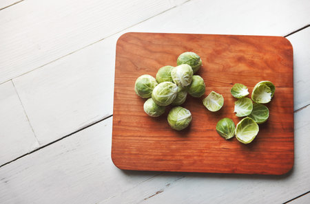 The health benefits of brussels sprouts are endless. fresh brussels sprouts on a wooden chopping...