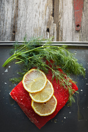 Protein appeal. a raw piece of meat garnished with slices of lemon.の写真素材