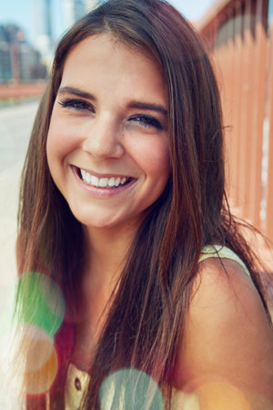 She has the most beautiful smile. a smiling young woman walking around the city in the summertime.の写真素材