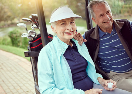 Anticipating a great game today. Portrait of a smiling senior couple riding in a cart on a golf course.の写真素材
