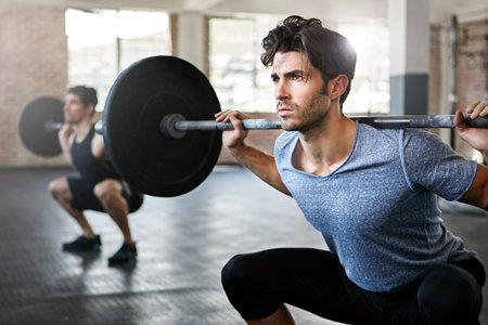Clean and jerk. young men working out with weights in the gym.の写真素材