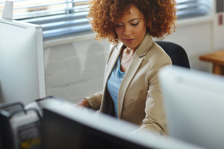 Working hard. a beautiful young businesswoman sitting in her office.の写真素材
