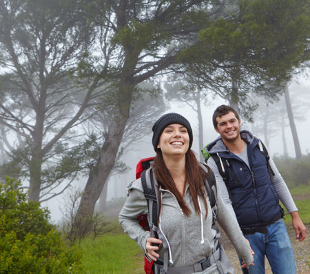 Nature is wonderful. a young couple hiking along a forest trail.の写真素材