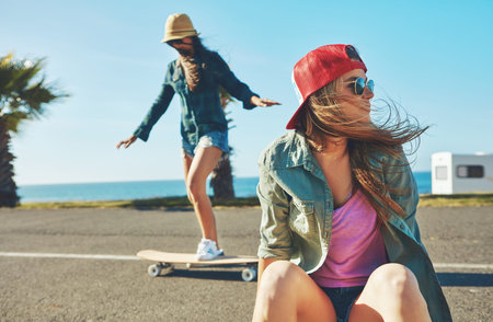 Enjoying the summer skateboarding. two friends hanging out on the boardwalk with a skateboard.