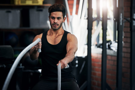 Im doing what need to be done. a handsome young man working out at the gym.