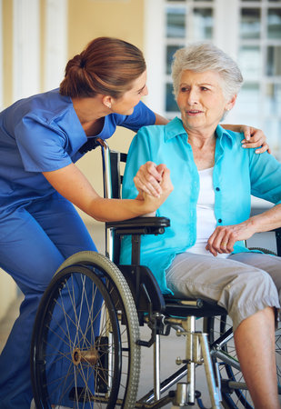 She puts her patients at ease. a doctor caring for her senior patient at a nursing home.の写真素材