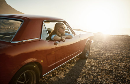 If youre looking for me, Im out on an adventure. a young woman enjoying a road trip along the coast.