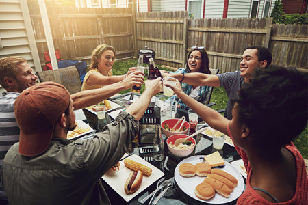 Our barbecues just get better every year. a group of friends having a barbecue in the yard.