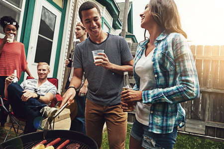 Spend great times with great people. a group of friends having a barbecue in the yard.