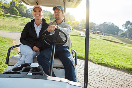 Driving back to the clubhouse. a young couple riding on a cart while enjoying a day on the golf course.の写真素材