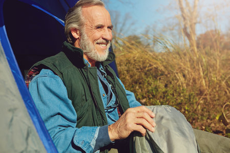 The view out here is breathtaking. a senior man camping in the wilderness.の写真素材
