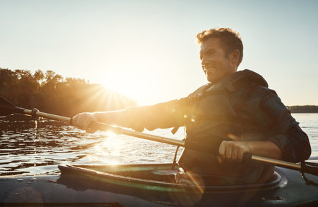 This is the place to be. a young man kayaking on a lake outdoors.の写真素材