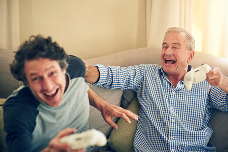 Dads got mad skills. a man and his elderly father playing video games at home.