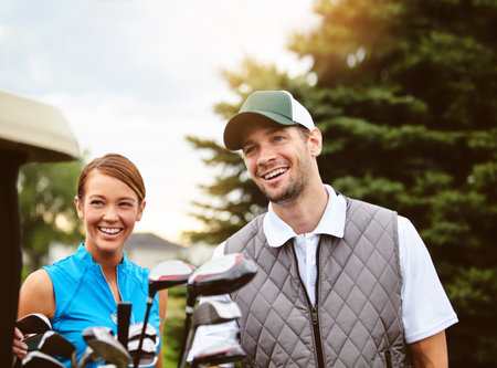 The green looks inviting. an affectionate young couple spending a day on the golf course.の写真素材