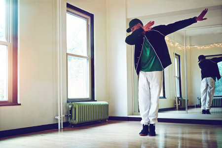 The dab is all about that swag. a young man dabbing during a dance routine in studio.の写真素材