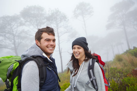Hiking is their idea of fun. a young couple enjoying a hike through nature.の写真素材