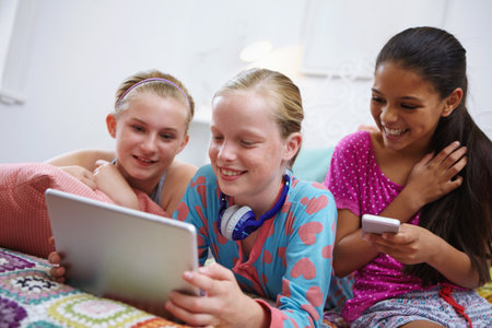 Teens and technology. a group of teenage friends using a digital tablet together.の写真素材