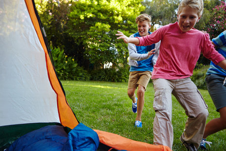 Boys will be boys. Full length shot of three young boys running into their tent.