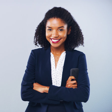 Work hard, have confidence, be a success. Studio shot of a confident young businesswoman posing against a grey background.の写真素材