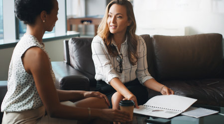 No one can plan like they do. two businesspeople having a discussion while sitting on a couch in a modern office.の写真素材