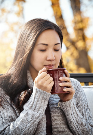 Its autumn, time to slow things down. an attractive young woman having a relaxing coffee break on an...