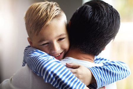 I love you tons, Dad. an adorable little boy hugging his father at home.の写真素材