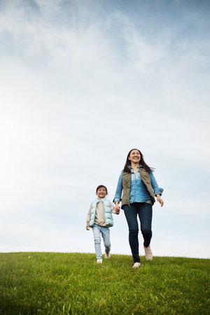 Life is beautiful, enjoy it. a woman holding her little girls hand as they walk outdoors.の写真素材