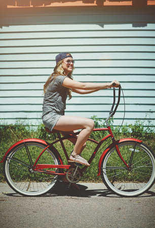 Go out and get some fun. an attractive young woman riding a bicycle outdoors.の写真素材