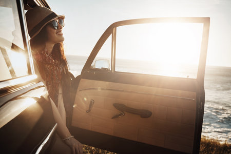 Nothing inspires happiness like summer. a young woman enjoying a road trip along the coast.の写真素材