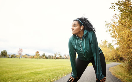 Appreciate any progress. an attractive young woman taking a break while out for a run in nature.
