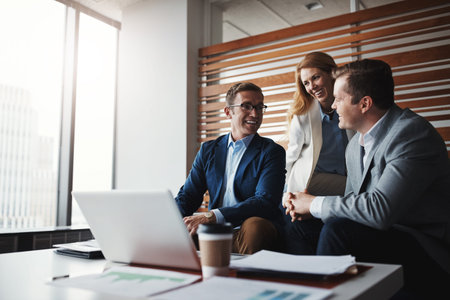 Working as a team of high-ranking executives. a group of businesspeople having a discussion in an...