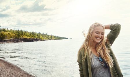 Treating herself to a day in nature. a young woman spending a day at the lake.の写真素材