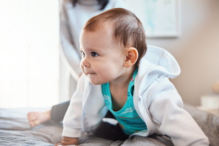The age of curiosity. an adorable baby girl playing on the bed at home.