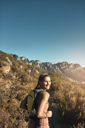What is life without a little adventure. Portrait of a young woman out on a hike through the mountains.の写真素材