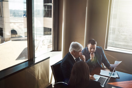 You need to meet to move forward. High angle shot of three businesspeople working in the boardroom.の写真素材
