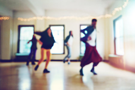 The masters in movement. Blurred shot of a group of young people dancing together in a studio.の写真素材