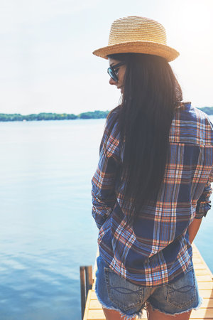 Shes happiest at the beach. an attractive young woman enjoying a day on the beach.の写真素材
