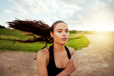 If it burns, youre doing it right. a fit young woman out for a run on a beautiful day.の写真素材