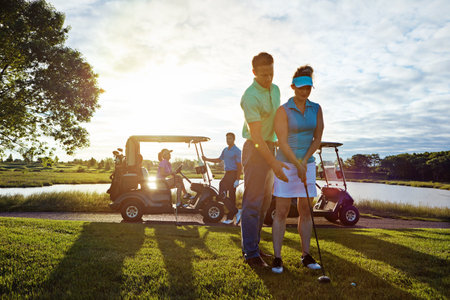 Youre a natural, babe. a husband helping his wife play golf.の写真素材