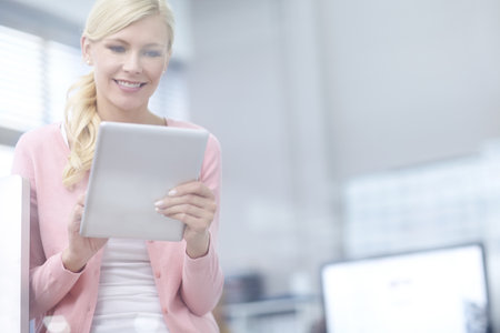 Business at my fingertips. an attractive young businesswoman using a digital tablet.の写真素材