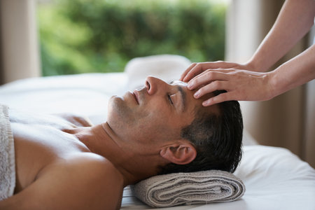 Enjoying a head massage. a mature man enjoying a relaxing masasage.の写真素材