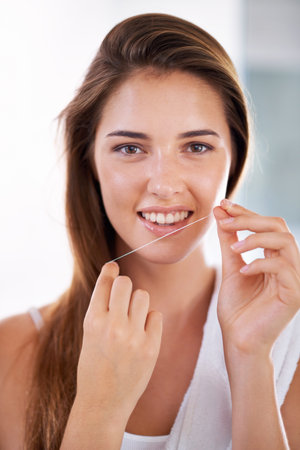 She knows the importance of flossing. Portrait of an attractive young woman holding dental floss and...