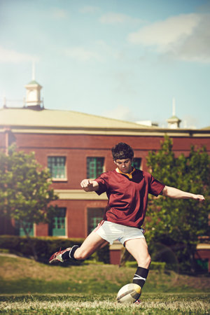His conversion rate it immense. Full length shot of a young rugby player kicking for poles.の写真素材
